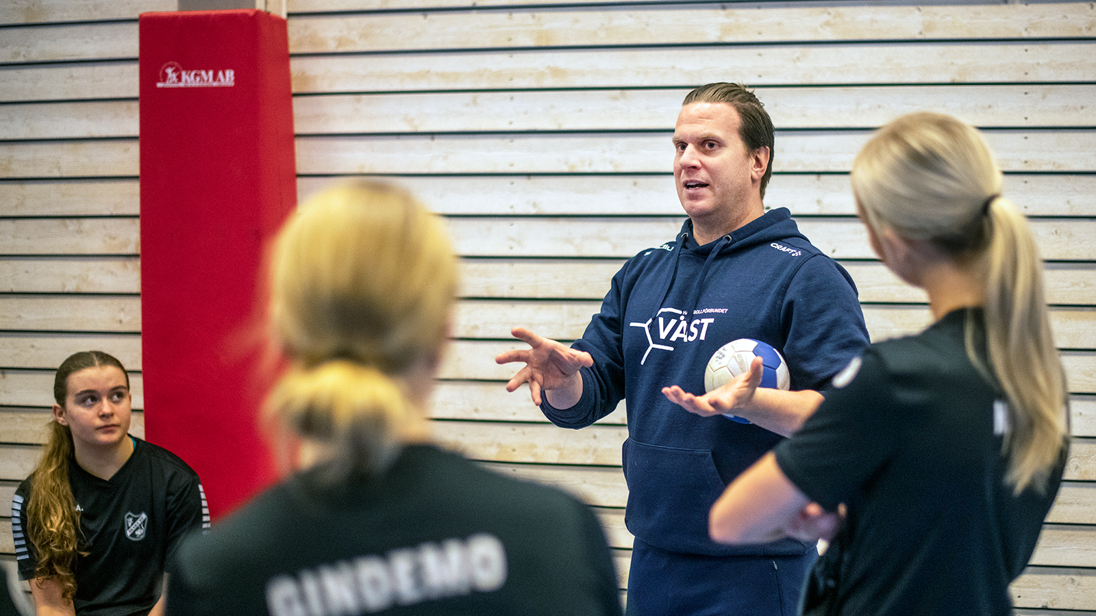 instruktör pratar med spelare och håller i en boll. Foto: Stefan Svensson